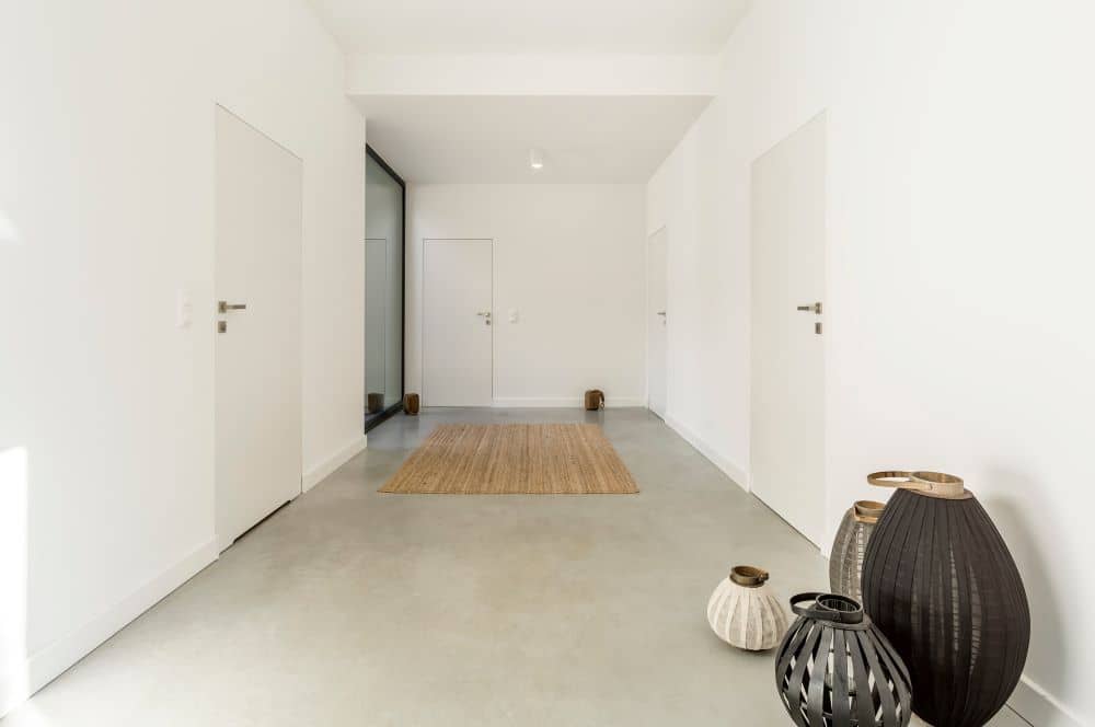 Hallway with white walls and concrete flooring.