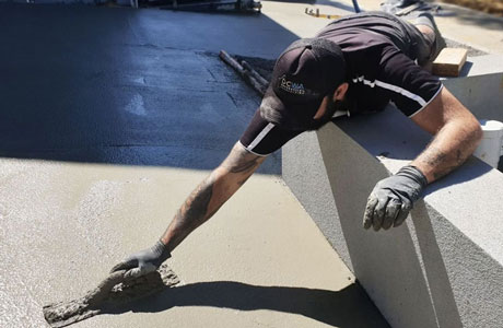 A worker from decorative concrete wa smoothing out some concrete in preparation for setting