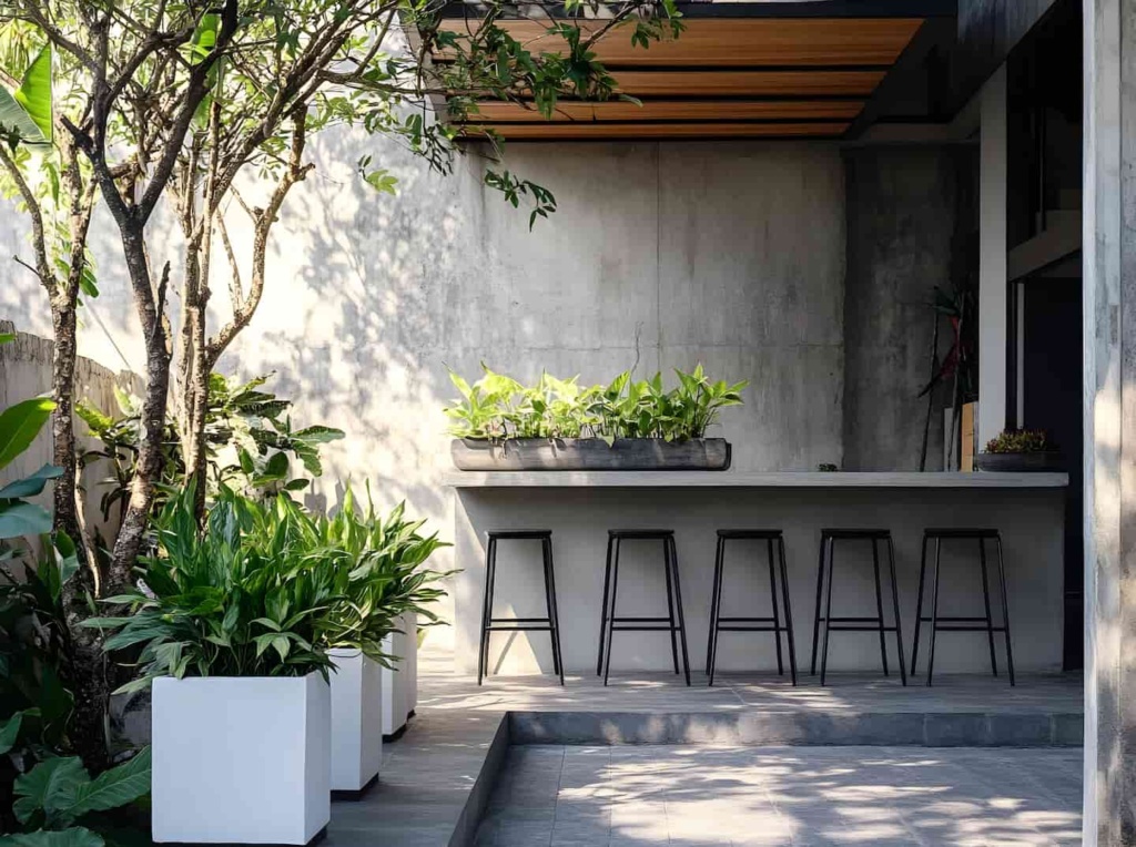 Concrete patio with bench and stool, plants and trees to the left showcasing an example of best materials for a patio