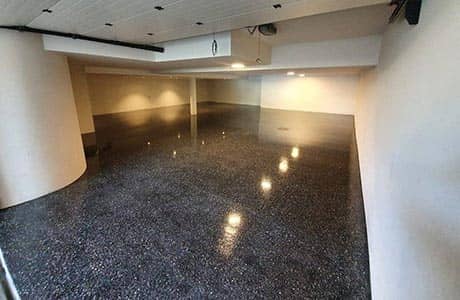 Honed aggregate concrete garage finish in Cottesloe, white walls with dark concrete surface