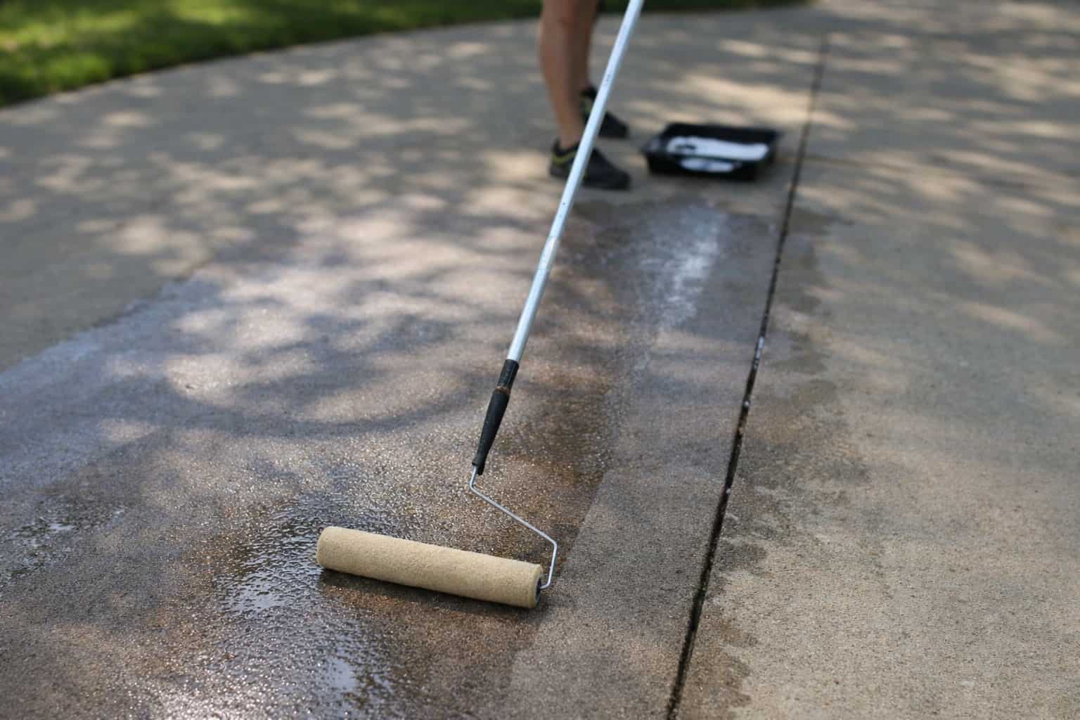 Concrete driveway being resealed in Perth, showing the difference between sealed and unsealed concrete surfaces.